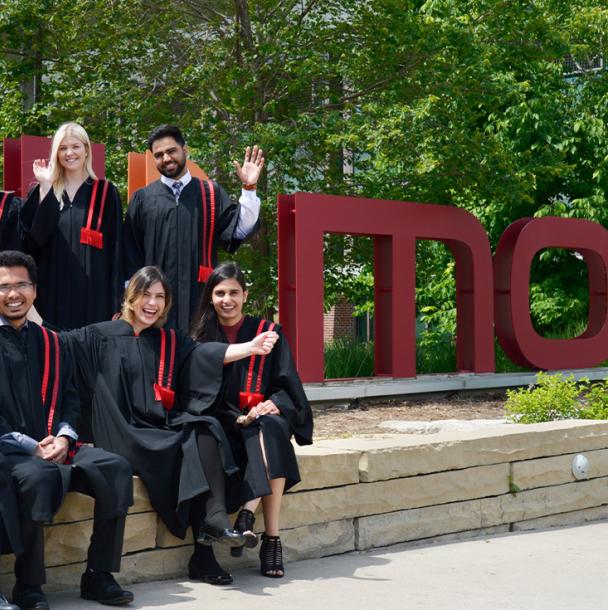 mohawk graduates posing in robes